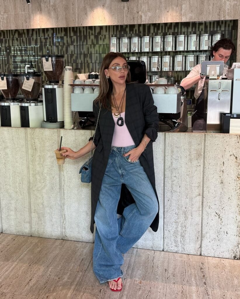 Mulher jovem usando sobretudo, regata, calça jeans e calçado colorido