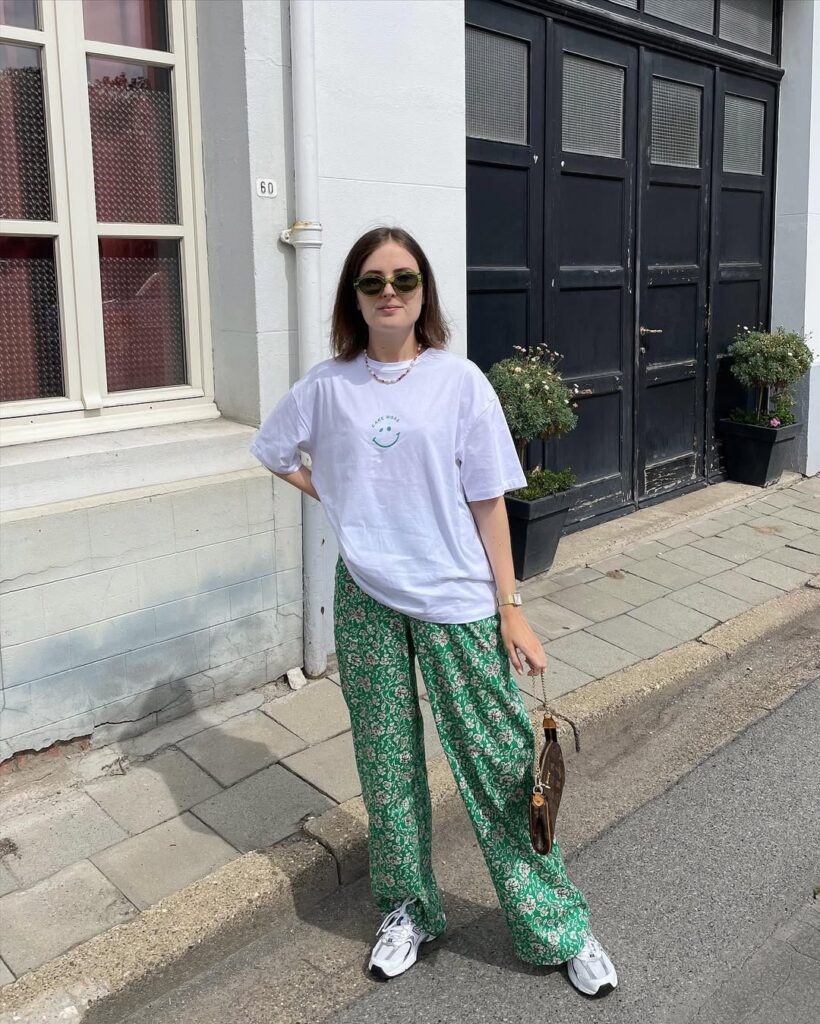 Mulher jovem com blusa branca, calça verde e tênis branco