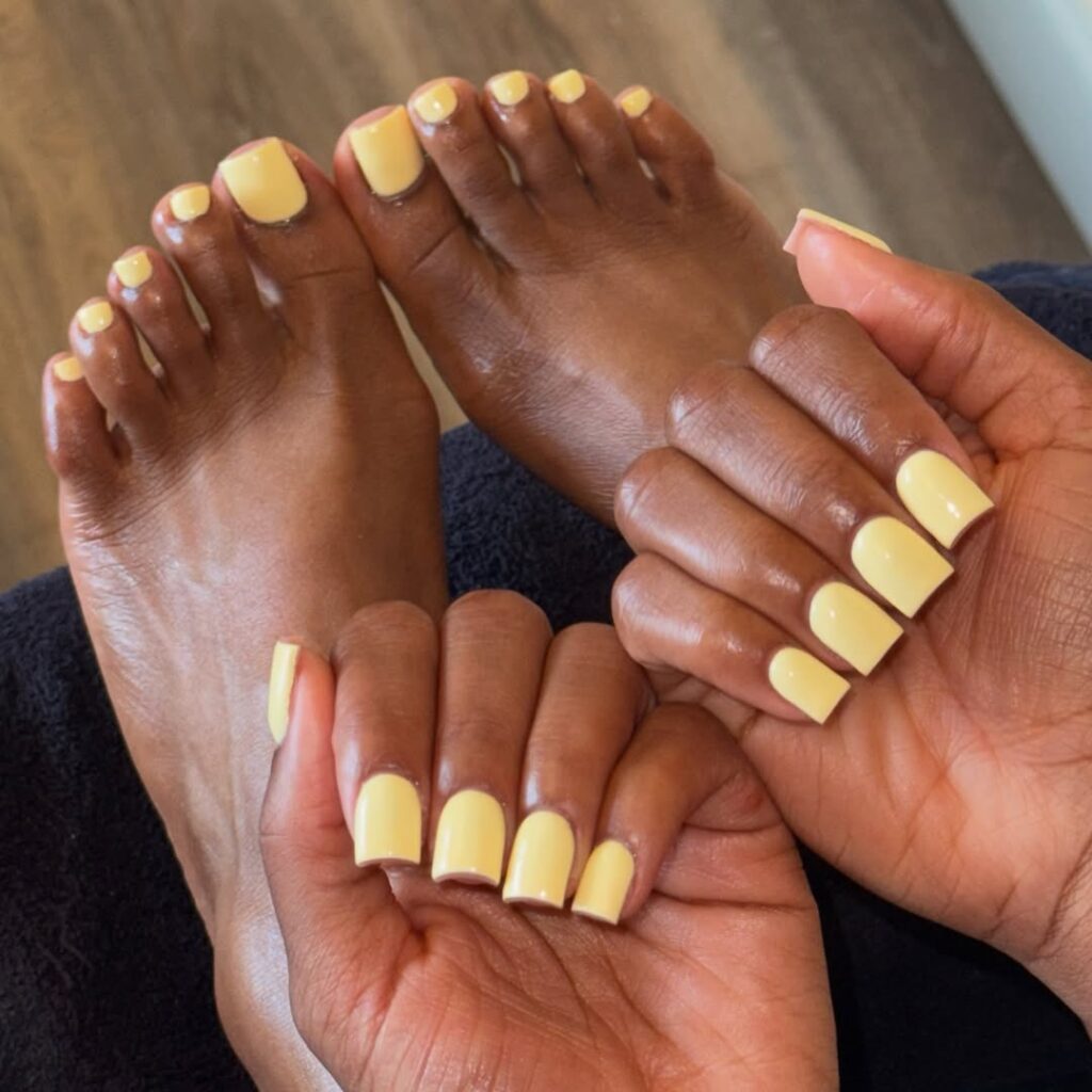 Pés e mãos de pele clara, com unhas amarelo-manteiga