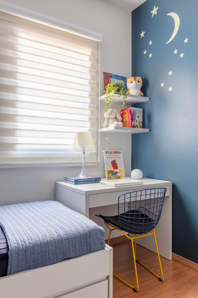 Quarto com parede azul, lua e estrelas brancas