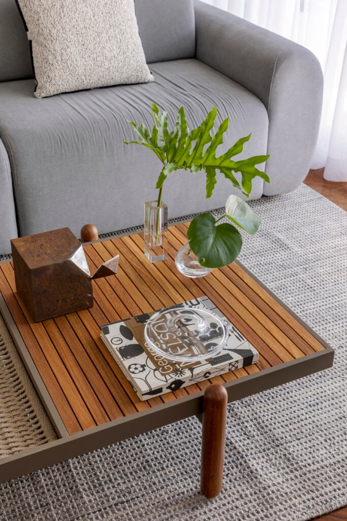 Sala com sofá cinza e mesa de centro de madeira