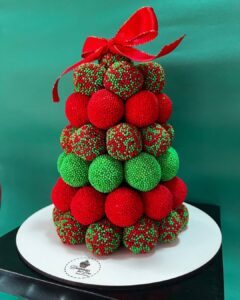 Pinheirinho com brigadeiros verdes, vermelhos e decorados com confeitos vermelhos e verdes