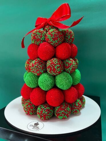 Pinheirinho com brigadeiros verdes, vermelhos e decorados com confeitos vermelhos e verdes