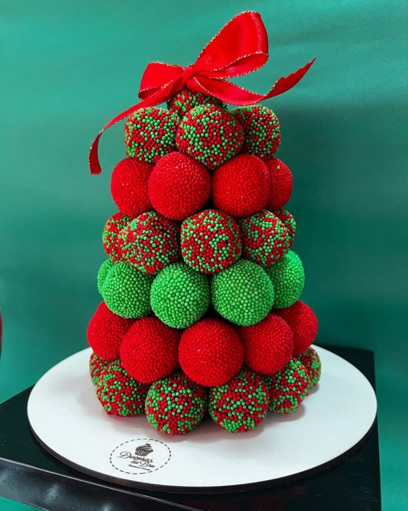 Pinheirinho com brigadeiros verdes, vermelhos e decorados com confeitos vermelhos e verdes