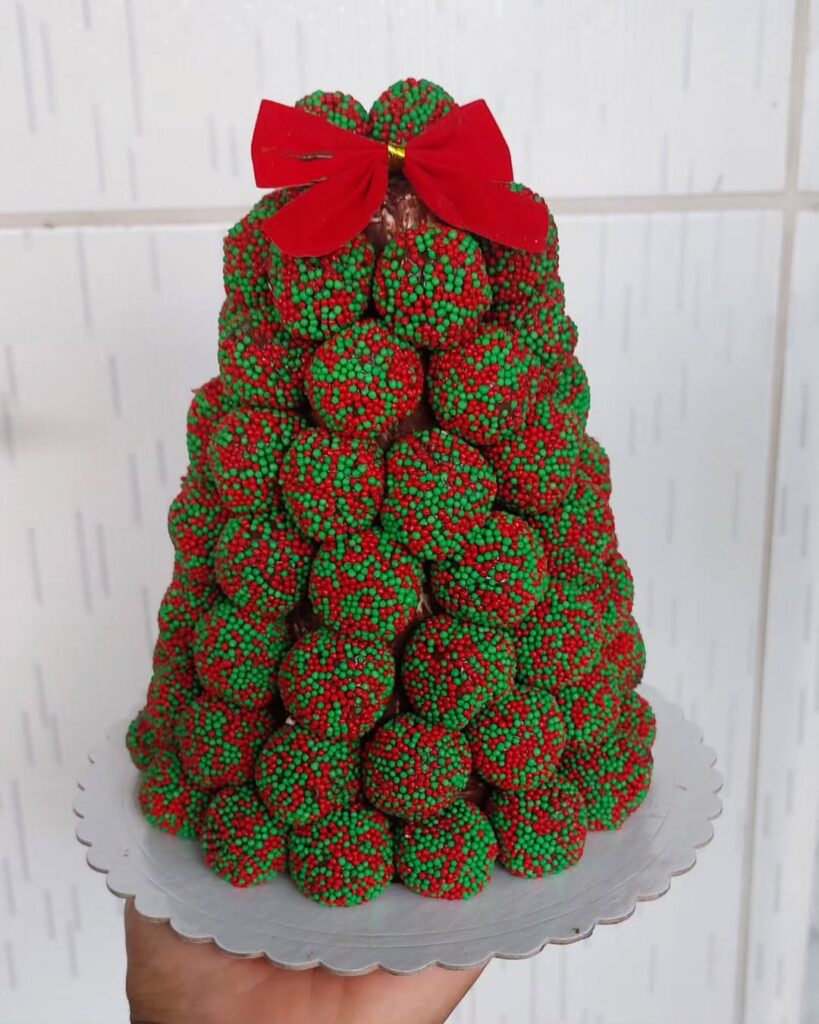 Árvore de Natal formada por brigadeiros com confeitos vermelhos e verdes
