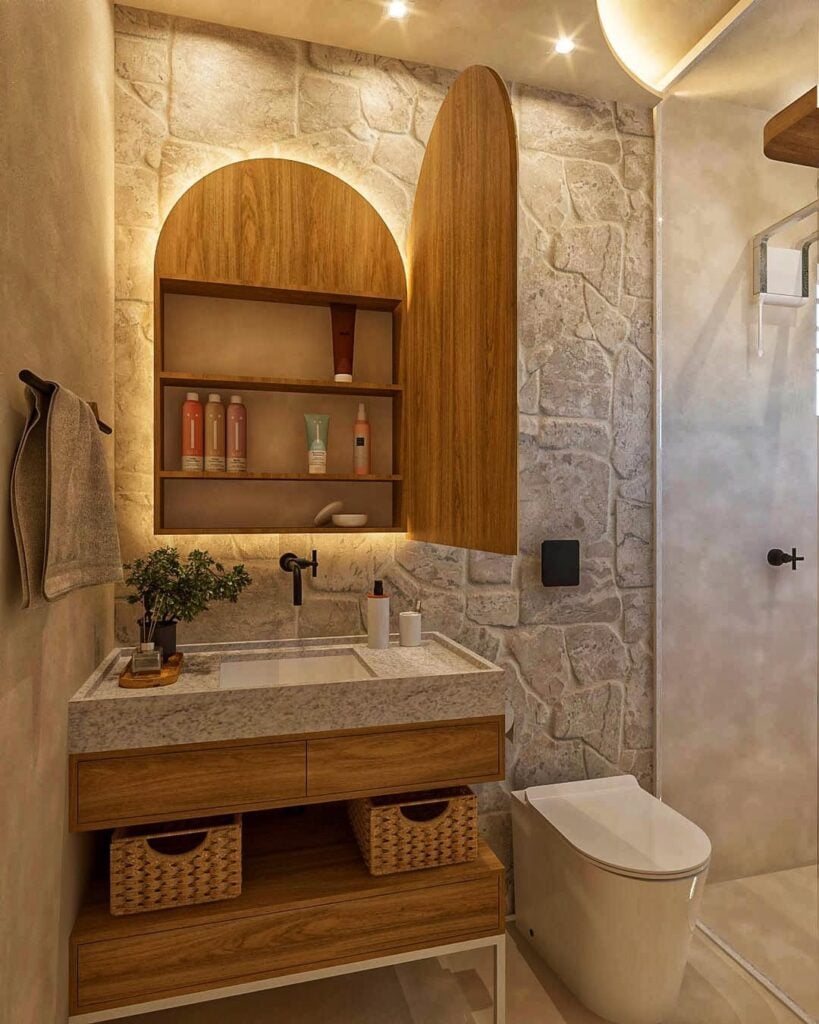 Banheiro no estilo spa com revestimento em pedras, armário com espelho e detalhes em madeira