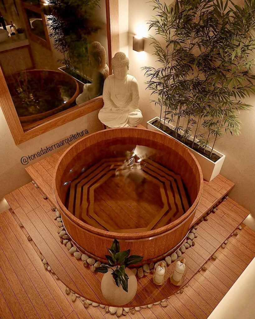 Banheiro spa com ofurô de madeira, estátua de buda e plantas