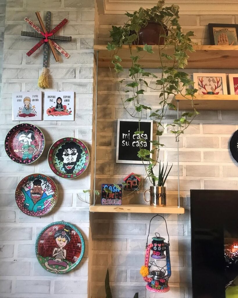 Canto de sala com prateleiras, pratos na parede e plantas
