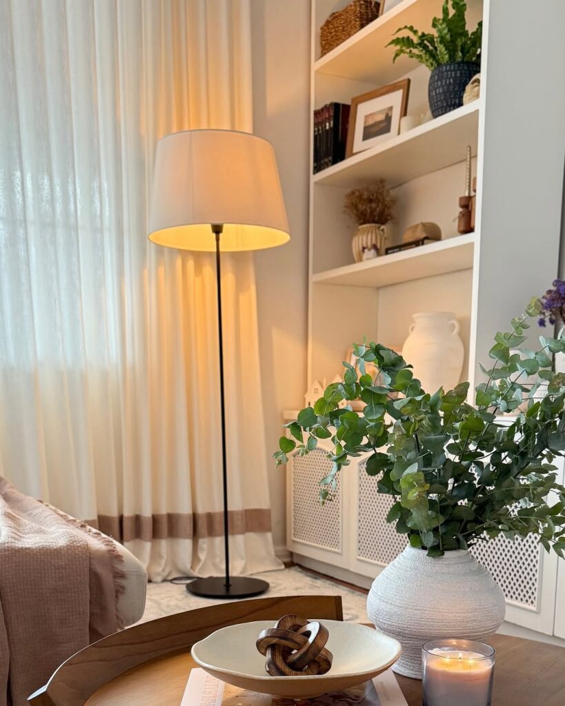 Sala com estante branca e luminária de piso