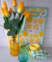 Vaso com tulipas amarelas, tábua com limões desenhados