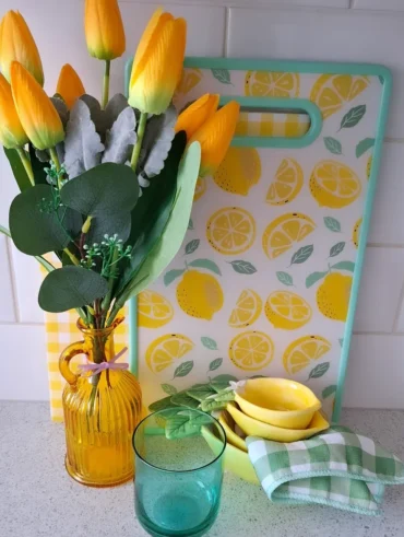 Vaso com tulipas amarelas, tábua com limões desenhados