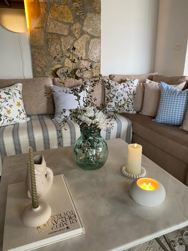 Sala de estar com almofadas de diferentes estampas e mesa com velas