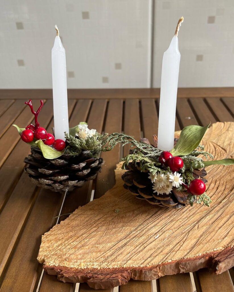 Pinhas decoradas com vela e florzinhas brancas