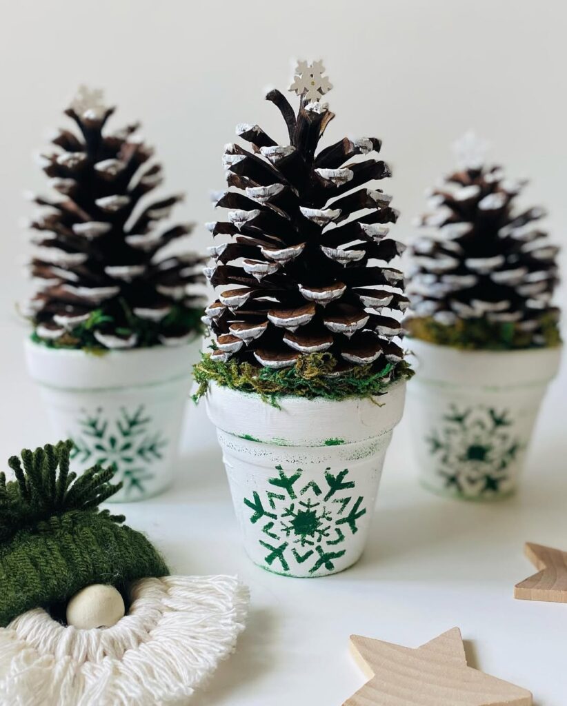 Vasinhos brancos decorados com pinhas com as pontas pintadas de branco