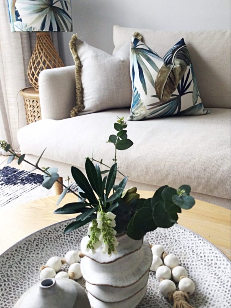 Sala com base neutra e almofada com estampa botânica
