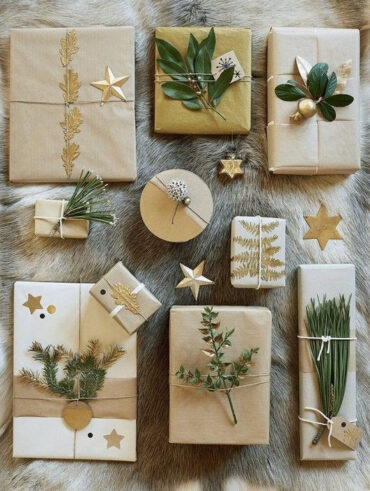 Caixas e embalagens de presente em papel pardo com folhas e estrelas douradas