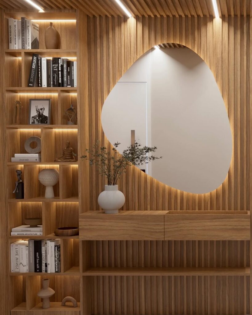 Hall decorado com painel ripado, aparador suspenso, espelho orgânico e estante com livros e objetos