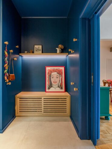 Hall de entrada com parede azul, quadro e prateleira