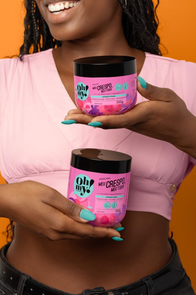 Mulher de pele preta com produtos da Oh My! 