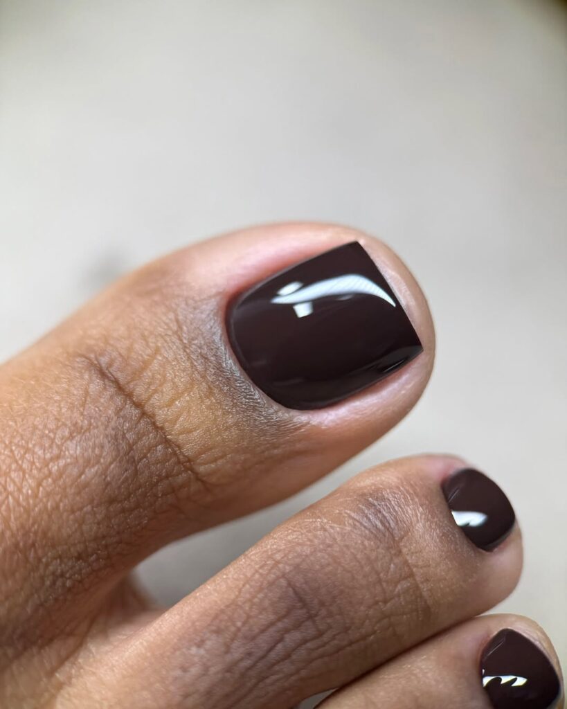 Pés de pele preta, com unhas marrom-escuro