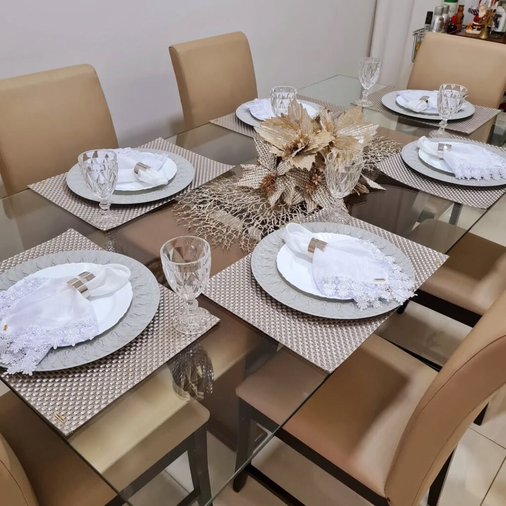 Mesa posta de Ano-novo com guardanapos brancos e centro de mesa dourado