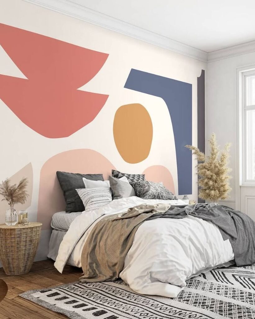 Quarto com tapete em cinza e preto e mural artístico em rosas, azul e bege
