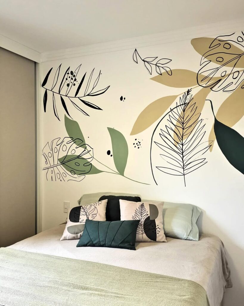 Quarto com folhas pintadas no lugar da cabeceira