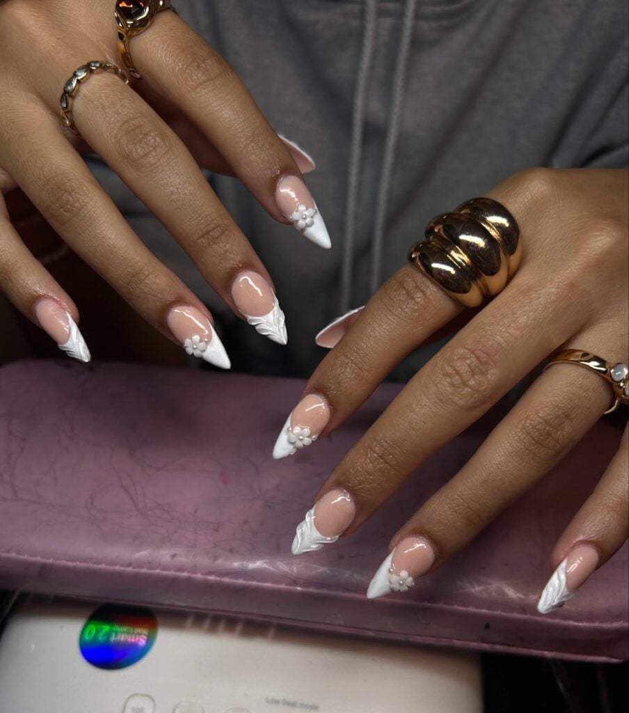 Mão de pele negra com esmalte branco com nail art de charms e esmaltação 3D de flores