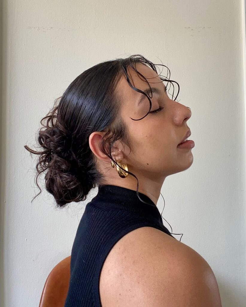 Mulher de pele preta, com cabelo preto preso em coque
