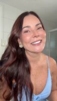 Mulher de pele clara, com cabelo escuro e blusa azul