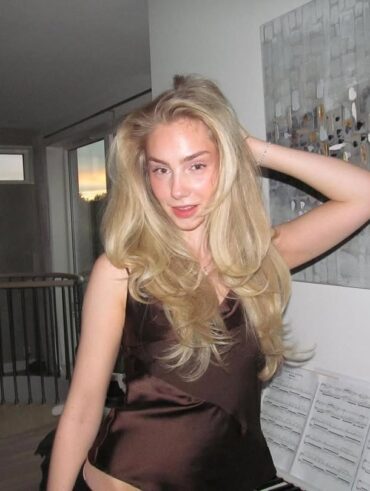 Mulher de pele clara, com blusa marrom e cabelo loiro