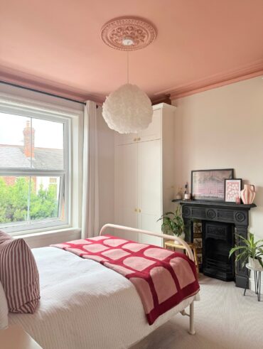 Quarto relaxante e rosa com branco, com cama, cômoda e TV