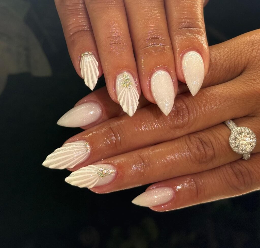 Mão de pele negra com esmalte branco com ténica nail art de sea nails para o Ano-Novo
