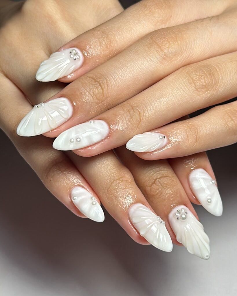 Mão de pele branca com esmalte branco com ténica nail art de sea nails ou mermaid nails para o Ano-Novo