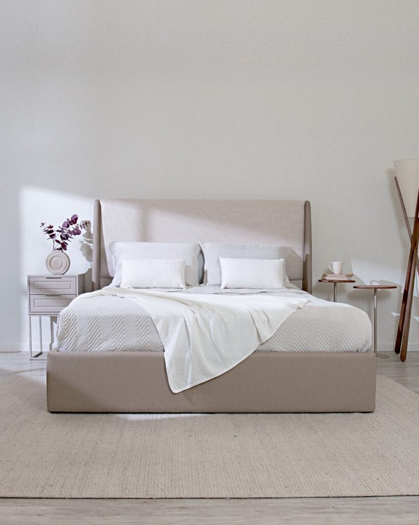 Quarto em tons neuros com mesas de cabeceira com design diferentes