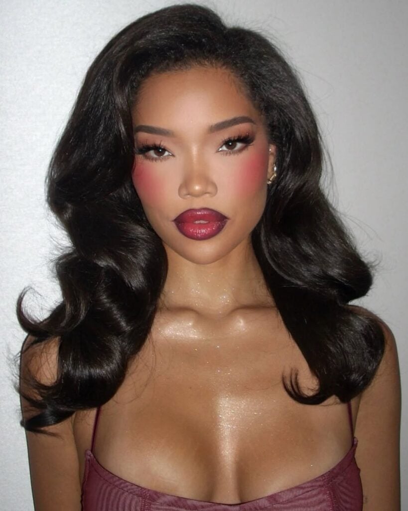 Mulher de pele preta, com cabelo escuro e maquiagem gótica suave