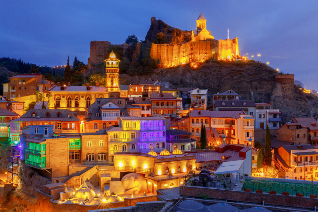 Paisagem ao anoitecer, várias casas coloridas em um monte