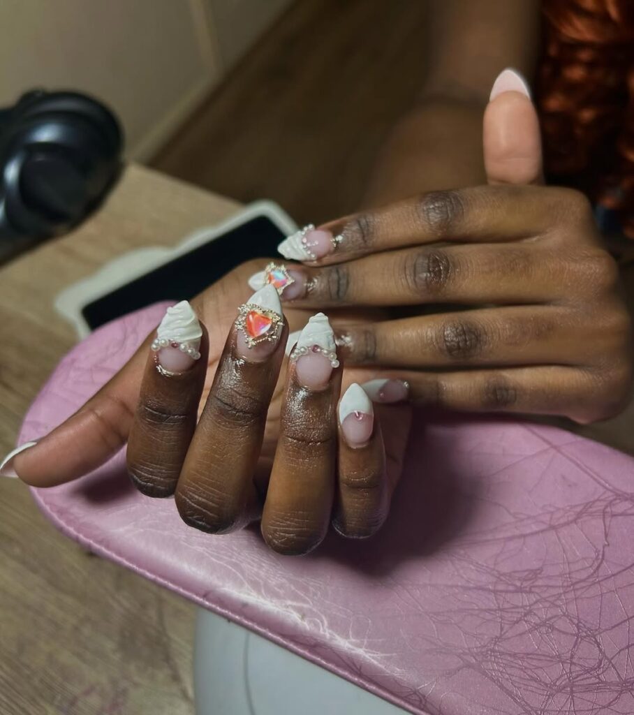Mão de pele negra com esmalte branco com nail art de coração