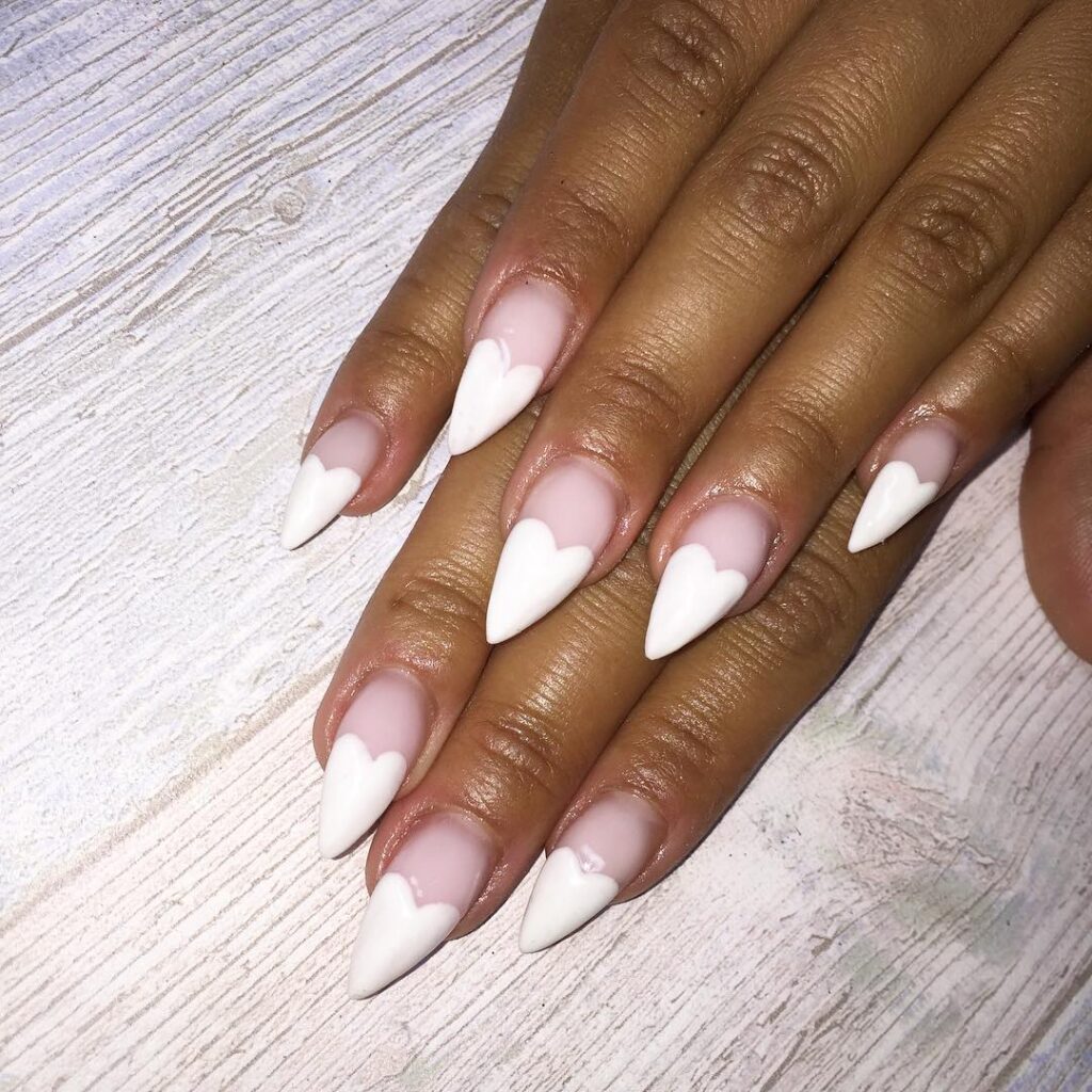Mão de pele negra com esmalte branco com nail art de coração