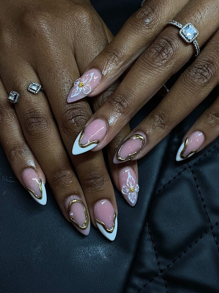 Mão de pele negra com esmalte branco com nail art de charms e esmaltação 3D de flores