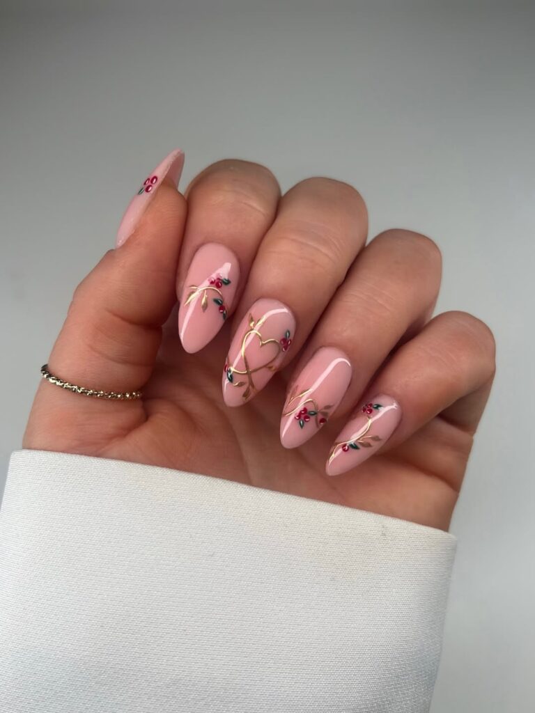 Mão de pele clara, com unha amendoada neutra com decoração em dourado