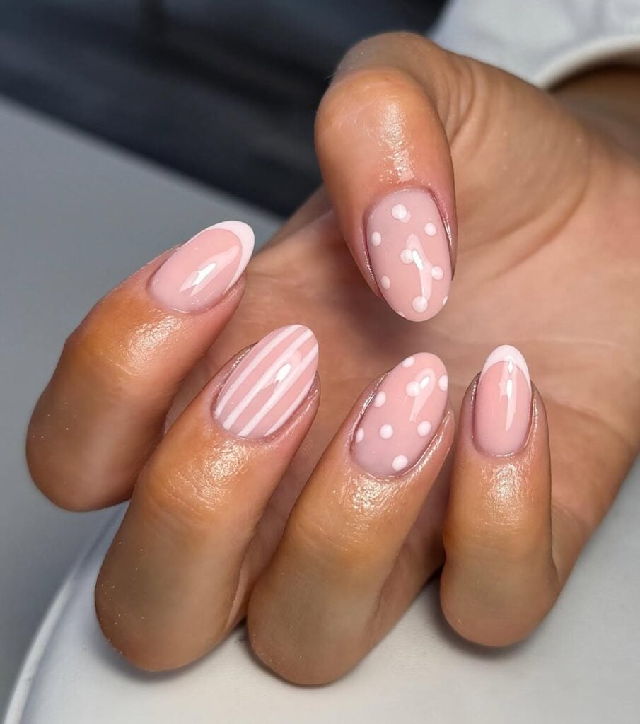 Mãos de pele preta-clara, com unha rosa-claro com decoração 