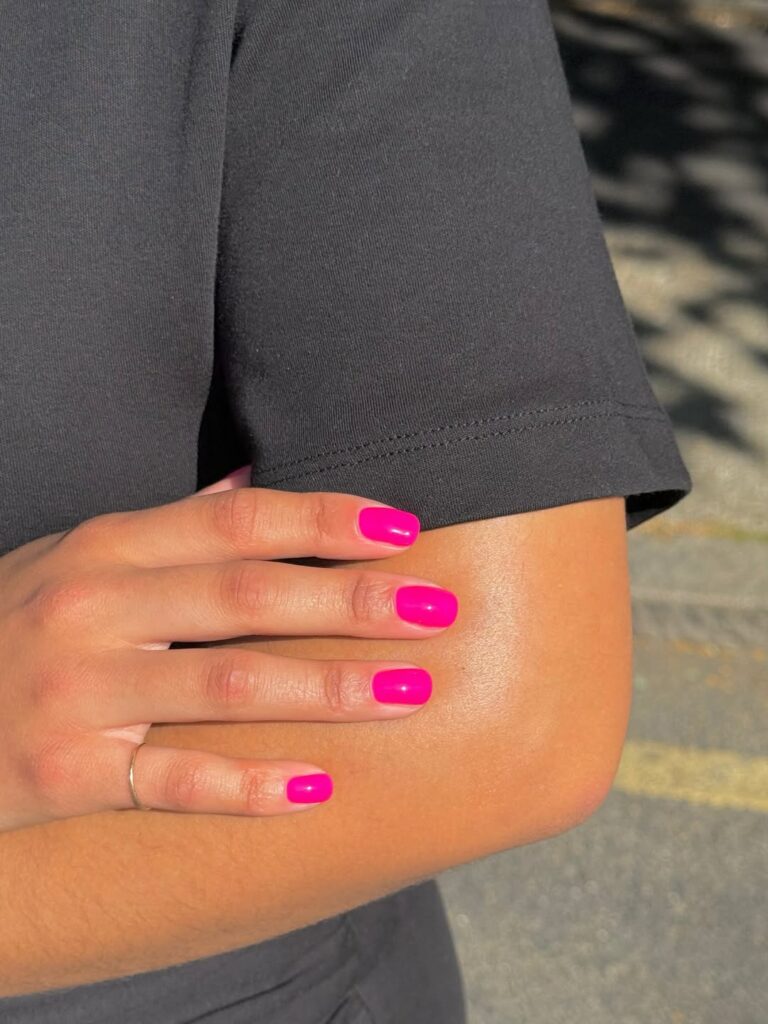 Mulher de pele preta, com unha curta pink