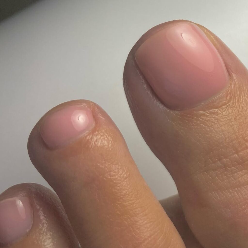 Pés de pele clara, com as unhas dos pés rosa blush