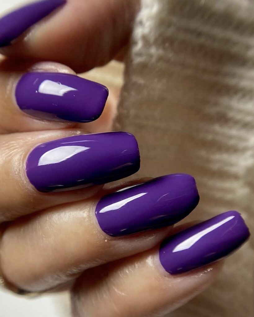 Mão de pele clara, com unha violeta