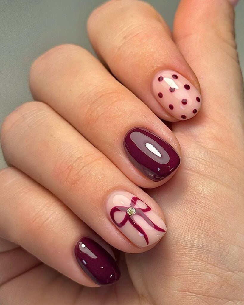 Mãos de pela clara, com unha burgundy com decoração