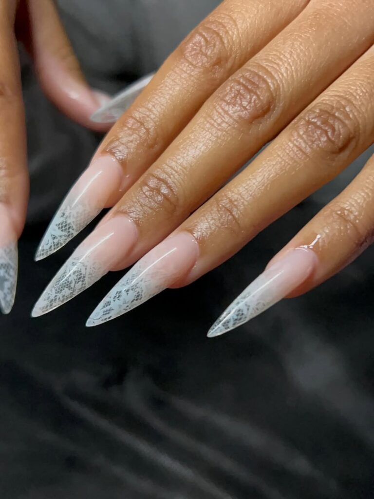 Mão de pele preta, com unha stiletto com renda