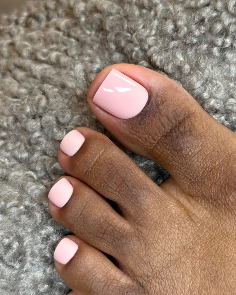 Pé de pele preta, com unha rosa-claro 
