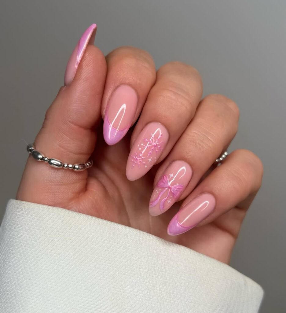 Mão de pele clara, e anéis em prata e unha amendoada rosa-claro e decorada