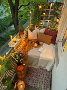 Varanda com clima de férias com almofadas, livro, luminárias e flores
